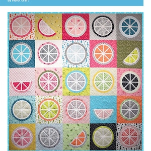 Puede incluir: Un edredón colorido titulado "the FRUIT JUICE quilt" de Violet Craft. El edredón presenta varios diseños de rodajas de fruta en un patrón de patchwork. Las rodajas de fruta son en tonos de rosa, naranja, verde y gris, con detalles de costura blancos.