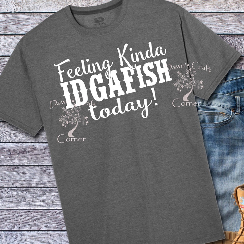 May include: A heather gray t-shirt with the text "Feeling Kinda IDGAFISH today!" in white. The text is surrounded by a stylized tree design with the words "Dawn's Craft Corner" on either side.