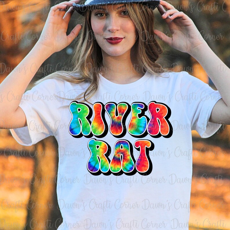May include: A white t-shirt with a tie-dye design that says "RIVER RAT" in rainbow colors.