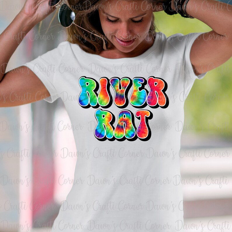 May include: A white t-shirt with a tie-dye design that says "RIVER RAT" in rainbow colors.
