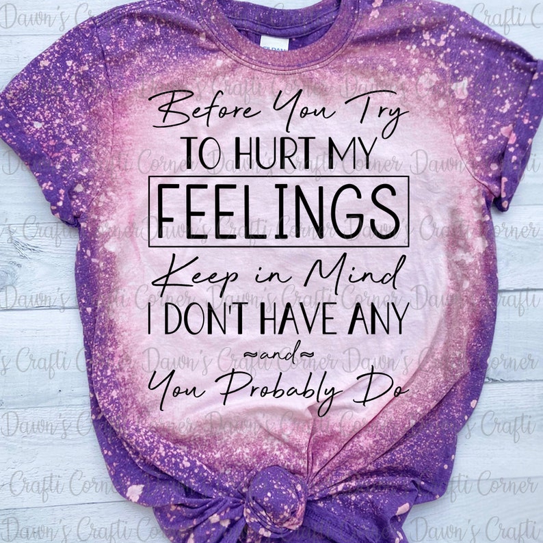 K&ouml;nnte beinhalten: Ein lila- und rosafarbenes Batik-T-Shirt mit dem Text "Before You Try To Hurt My Feelings Keep In Mind I Don't Have Any And You Probably Do" in Schwarz.