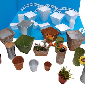 May include: Assortment of decorative planters in various shapes, sizes, and colors, including white, brown, green, and gray. Some planters have a woven texture. The planters are arranged on a blue surface with a white background.