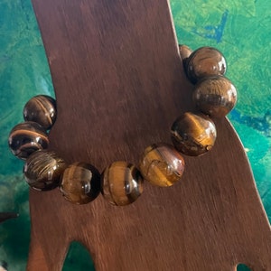 May include: A brown tiger's eye gemstone bracelet with round beads.