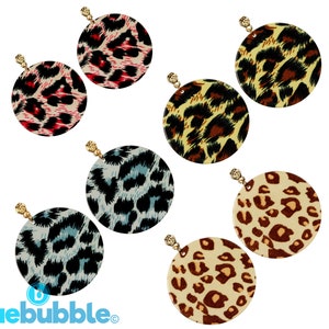 May include: Six pairs of leopard print earrings. Each pair features a large, round, gold-toned earring with a different color leopard print pattern. The patterns include pink, blue, yellow, brown, and black.
