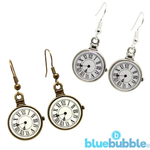 May include: A pair of silver and bronze earrings with a clock face design. The clock face has Roman numerals and a black hand.