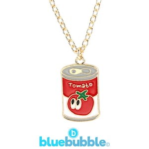 Peut inclure: Un collier en chaîne dorée avec un pendentif en forme de boîte de conserve de tomate rouge et blanche avec le mot "Tomate" imprimé dessus.