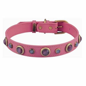 Op de afbeelding: Roze leren hondenhalsband met gouden accenten en paarse en blauwe edelstenen.