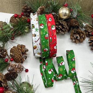 May include: Three rolls of Christmas-themed elastic ribbon. The ribbon is green, red, and white with a snowman, candy cane, and star pattern.