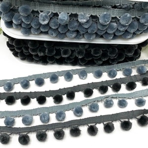 May include: Four rows of grey and black pom-pom trim. The trim is made of soft, fuzzy fabric and is perfect for adding a touch of texture to any project.