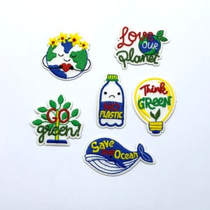 Puede incluir: Seis parches bordados para planchar con temática ambiental. Los parches muestran una tierra sonriente con una corona de flores, una botella de agua triste con el texto "No Plastic", una bombilla con una planta dentro y el texto "Think Green", un árbol verde con el texto "Go Green", una ballena azul con el texto "Save Our Ocean", y una tierra verde con el texto "Love Our Planet".