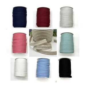 May include: Spools of different coloured fabric trim, including navy blue, burgundy, white, beige, light pink, light blue, and black.