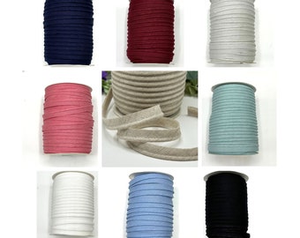 May include: Spools of different colored fabric trim, including navy blue, burgundy, white, beige, light pink, light blue, and black.