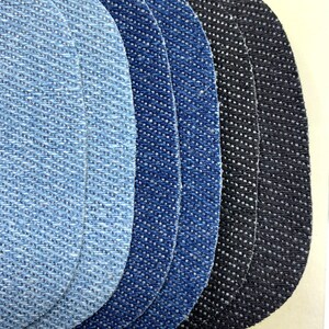 May include: Five denim fabric swatches in different shades of blue and black. The swatches are arranged in a semi-circle, with the lightest blue swatch at the top and the darkest black swatch at the bottom.
