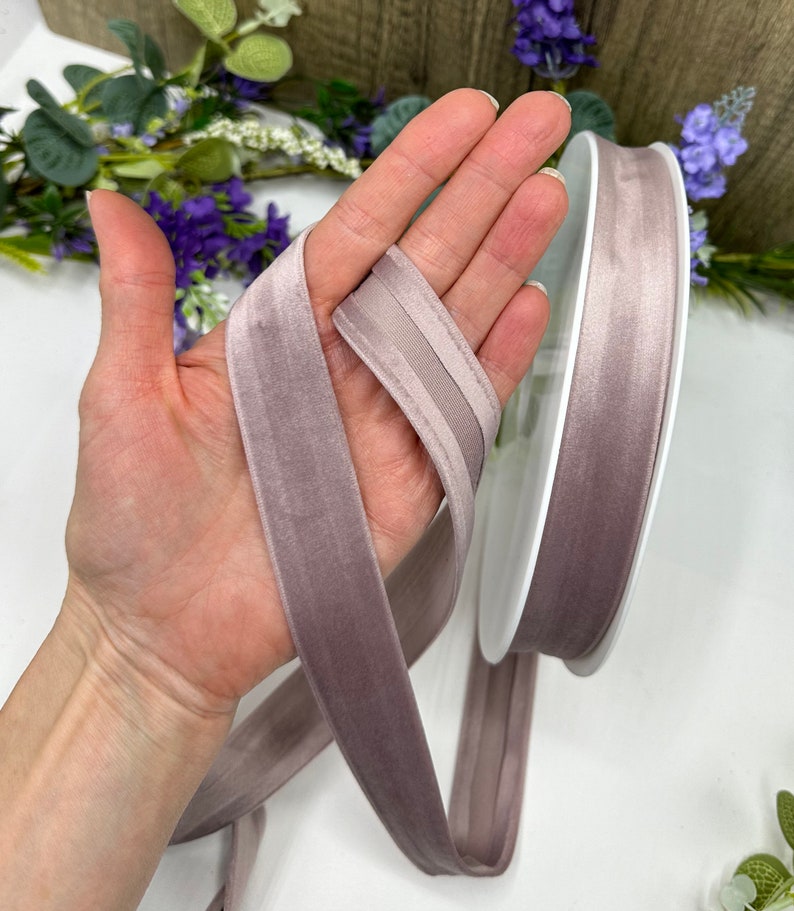 K&ouml;nnte beinhalten: Eine Rolle mauvefarbenes Samtband mit Satin-Kante. Das Band ist etwa 2,5 cm breit.