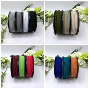 May include: A set of ten spools of elastic cord in various colors, including black, white, gray, green, red, blue, teal, and orange. The spools are arranged in pairs on a white surface.