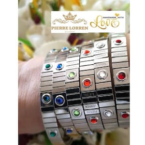 May include: A set of five silver bracelets with black accents and colorful gemstones. Each bracelet has the text "PIERRE LORREN" and "S.STEEL" engraved on it. The bracelets are handmade with love.