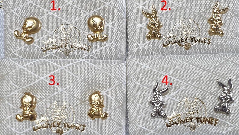 May include: Four pairs of gold and silver Looney Tunes earrings. The earrings feature Bugs Bunny and Tweety Bird.