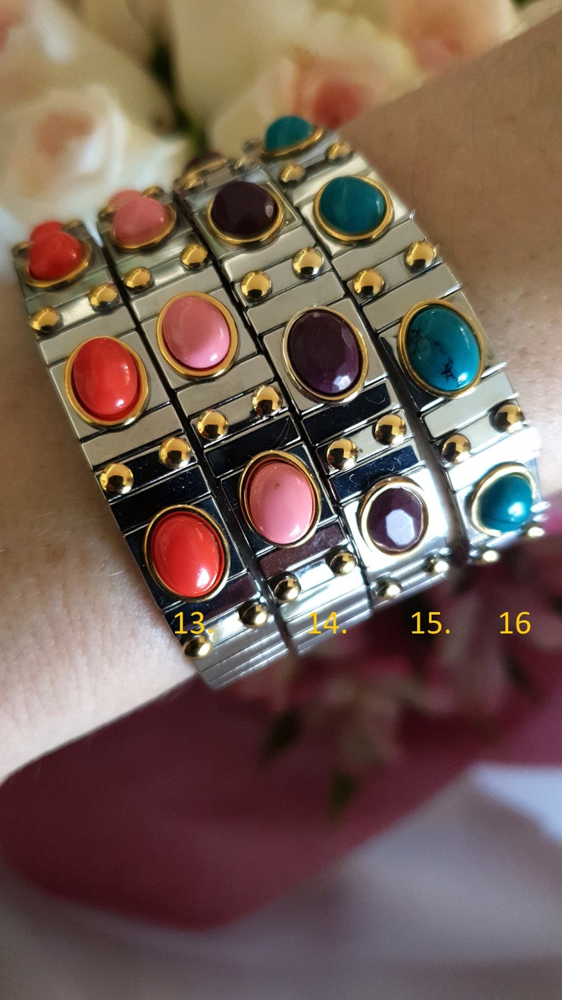 May include: Four silver bracelets with colourful oval-shaped stones. The bracelets are numbered 13, 14, 15, and 16.