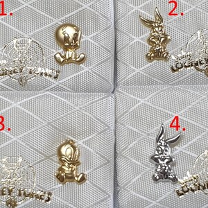 May include: Four pairs of gold and silver Looney Tunes earrings. The earrings feature Bugs Bunny and Tweety Bird.