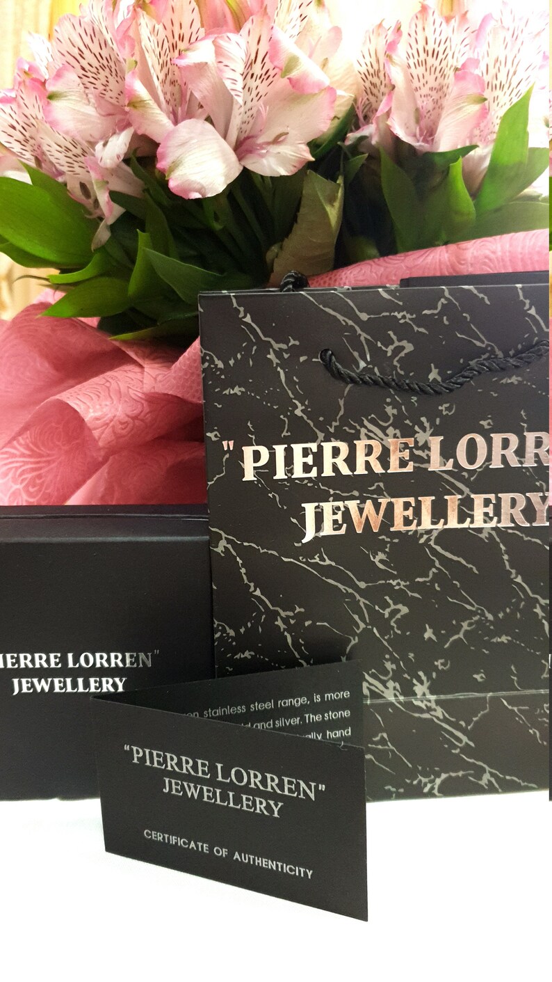 Puede incluir: Un certificado de autenticidad en blanco y negro para joyer&iacute;a Pierre Lorren. El certificado est&aacute; sobre un fondo negro con texto blanco. El texto dice "Pierre Lorren" Joyer&iacute;a Certificado de autenticidad.
