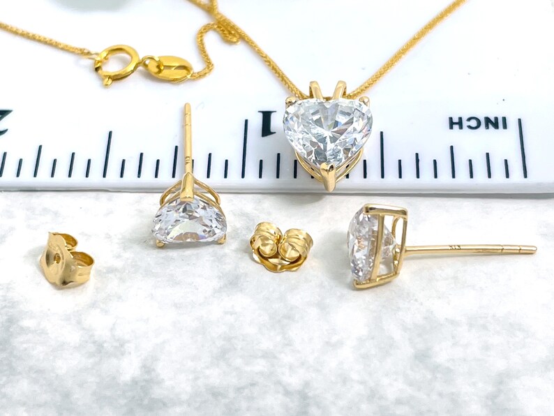 Pu&ograve; includere: Una collana con ciondolo a forma di cuore in oro e orecchini abbinati con zirconi cubici trasparenti. La collana &egrave; lunga 45,7 cm e il ciondolo ha un diametro di 2,5 cm. Gli orecchini hanno un diametro di 1,2 cm.
