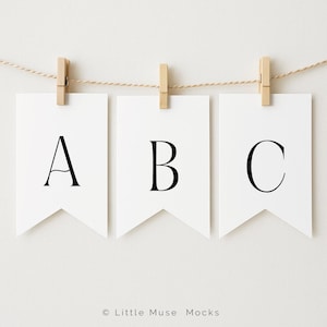 Könnte beinhalten: Drei weiße Wimpelbanner mit den schwarzen Buchstaben A, B und C, aufgehängt an einer Schnur mit Holzklammern. Das schlichte Design eignet sich gut für ein Kinderzimmer oder eine Veranstaltung.