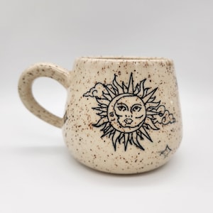 Op de afbeelding: Een set van drie keramische mokken met een gespikkelde, matte afwerking. De mokken zijn in de kleuren crème, lichtbruin en donkerbruin. Elke mok heeft een eenvoudig, minimalistisch ontwerp en een afgeronde handgreep.