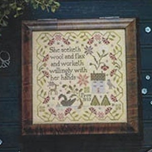 May include: A cross stitch sampler pattern featuring a verse from Proverbs 31, "She seeketh wool and flax, and worketh willingly with her hands." The pattern is framed in a dark wood frame and is surrounded by a dark blue background.