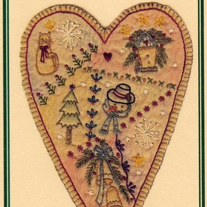 May include: A heart-shaped embroidered fabric panel with a winter theme. The panel features a snowman, a Christmas tree, a cat, a birdhouse, and bells. The panel is decorated with snowflakes, stars, and other winter motifs.