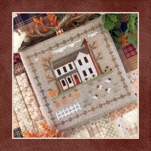 May include: Cross-stitch sampler depicting a two-storey house with a red door and a barn, surrounded by pumpkins and autumn foliage. The sampler has a decorative border and the word "Harvest" is stitched at the bottom.