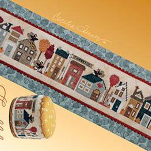 Può includere: Modello di punto croce per un progetto di ricamo a punto d'ago a tema Ringraziamento con una fila di case e il testo "Thankful tiny town" e "Heart & Hand Designs" nell'angolo.