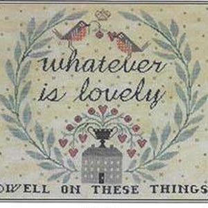 Puede incluir: Patrón de punto de cruz con una corona de hojas verdes y una casa con techo rojo. Dos pájaros están posados en una rama sobre la casa, sosteniendo una baya roja. El texto "whatever is lovely dwell on these things" está escrito en un círculo alrededor de la casa.