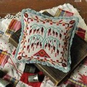 Pode incluir: Uma pequena almofada quadrada de ponto de agulha azul e branca com uma borda vermelha e branca. A almofada apresenta um desenho de uma árvore de salgueiro chorão com uma base vermelha.