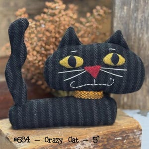 May include: A black fabric cat with yellow eyes, a red nose, and white whiskers. The cat has a gold collar and a curved tail. The text "#684 - Crazy Cat - 5" is at the bottom. The cat is approximately 5 inches tall.