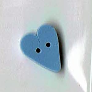 May include: A light blue heart-shaped button with two holes.