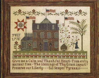 May include: A cross-stitch pattern featuring a brick house with a red roof, a star quilt, and a tree with red birds. The text "July 1776" is stitched above the house. The text "Give me a Calm and Thankful Heart From every murmur free. The blessings of Thy Grace impart. Preserve our Liberty. Sic Semper Tyrannis..." is stitched below the house.