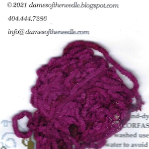 May include: A close-up of a ball of deep magenta yarn. The yarn is thick and textured, with a soft, fuzzy appearance. The image includes the text "Ida Neel's Cherries" and contact information.