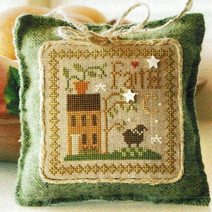 May include: A green fabric pillow with a brown burlap square stitched on the front. The burlap square features a cross-stitch design of a small house with a tree, a bird, and the text "Sweet Home".