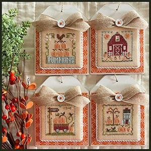 May include: Four framed cross-stitch samplers with fall themes. Each sampler features a burlap bow with a button. The designs include pumpkins, a rooster, a barn, and a wagon. The frames have an orange and white patterned border.