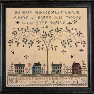 May include: Cross-stitch embroidery featuring a tree, houses, birds, and the text "IN OUR HOME LET LOVE ABIDE and BLESS ALL THOSE WHO STEP INSIDE" along with the alphabet and numbers.