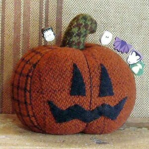 May include: A brown felt pumpkin with a black felt face, a green felt stem, and various felt Halloween decorations pinned to it.