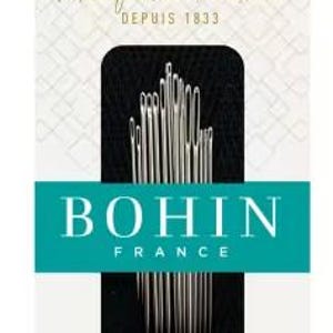 May include: A package of Bohin France textile arts needles. The package has a white background with a teal banner that reads "BOHIN FRANCE". The text "Manufacture Française DEPUIS 1833" is printed in gold script. The package includes an assortment of needles.