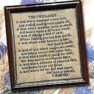 May include: A framed cross-stitch sampler on tan fabric featuring the poem The Two Lands by C. Rossetti in black thread. The piece is enclosed in a dark brown wooden frame with a simple rectangular profile and a clear glass front covering the embroidery.