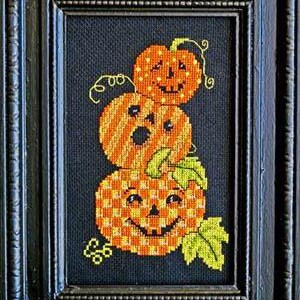 Peut inclure: Une pile de trois citrouilles orange et jaunes en forme de jack-o'-lantern avec des yeux et une bouche noirs. Les citrouilles sont empilées les unes sur les autres et ont des tiges vertes.