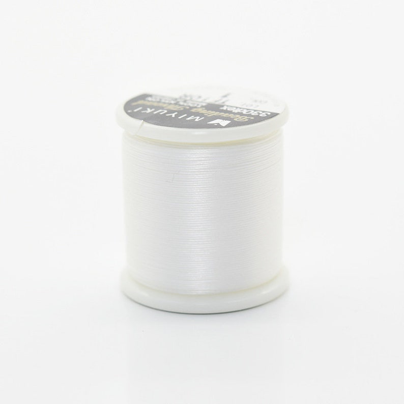 May include: A white spool of thread with the text "Miyuki Super Strong 250m" on the label.