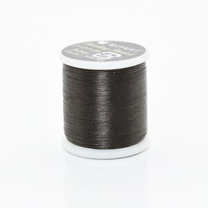 May include: A spool of black waxed thread for sewing or crafts. The spool is labeled "Miyuki" and "100% Polyester - Thread".