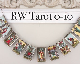 May include: A banner of tarot cards hangs from a white shelf with the text "RW Tarot o-io" above it. The cards are from a Rider-Waite tarot deck and include The Magician, The Empress, The Emperor, The Chariot, The Lovers, The Hierophant, The Star, and The Wheel of Fortune.
