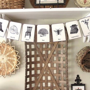 May include: A black and white printable banner with various images and words, including "shoe", "bicycle", "chair", "fan", "bee", "typewriter", "carrot", and "balloon".