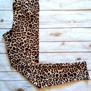 May include: Leopard print leggings with a high waist and a brown and tan colour scheme.