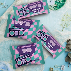 以下が含まれることがあります： 90年代をテーマにしたキャンディーバーの包装紙がいくつかあります。包装紙は、ピンクとティール色の市松模様で、紫色のバナーには「Back to the 90's」と「Olivia's 30th Birthday」と書かれています。各包装紙には、ブームボックスのグラフィックがあります。